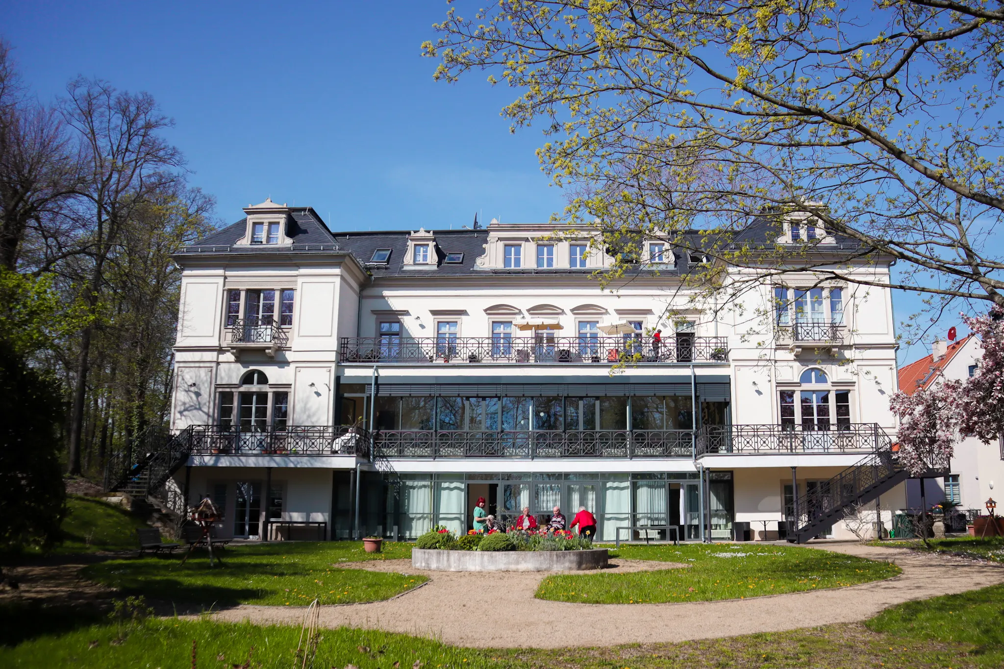 Katharinenhof Meißen-Plossen vom Garten aus – Hauptgebäude mit Terrasse und Sitzplätzen für Gemeinschaft